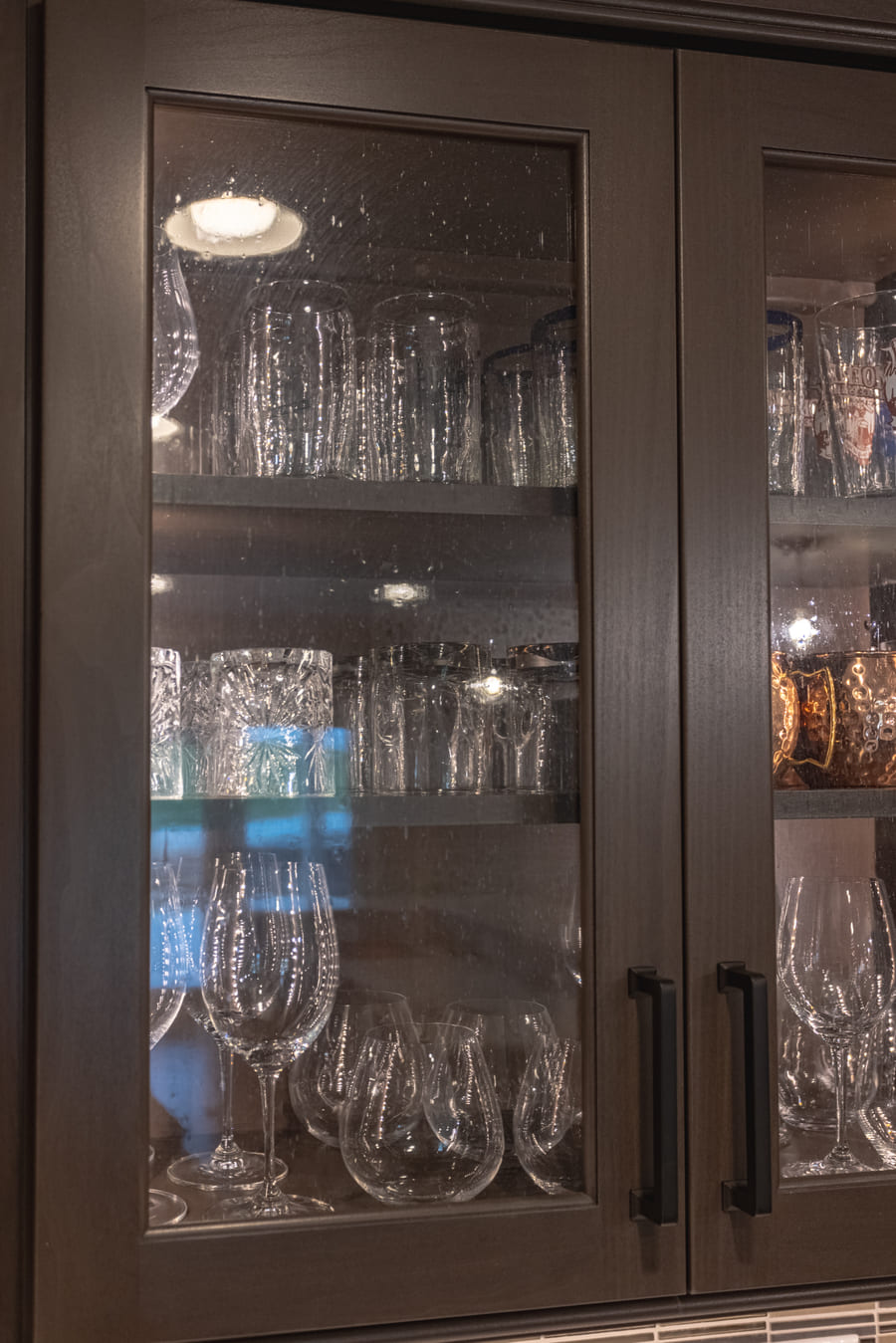 Semi-custom glass panel cabinets in basement remodel