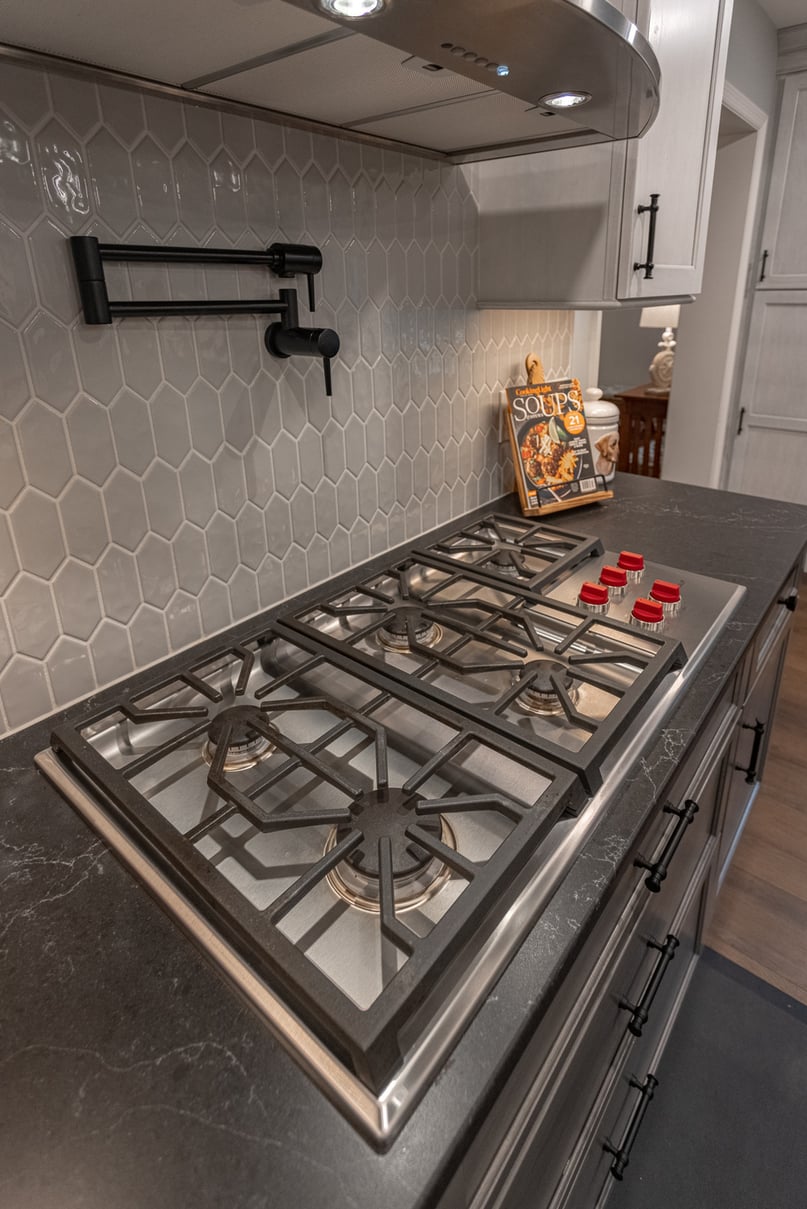 gas range hood with pot filler and elongated hexagonal tile backsplash kitchen remodel in Montogomery by Legacy Builders Group