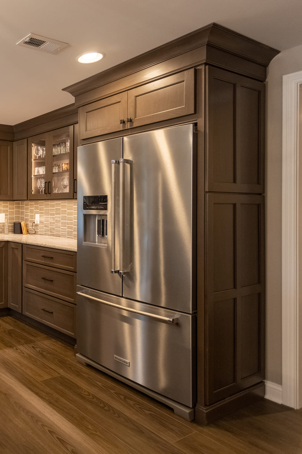 Stainless steel fridge with above cabinet storage in Ross County basement remodel