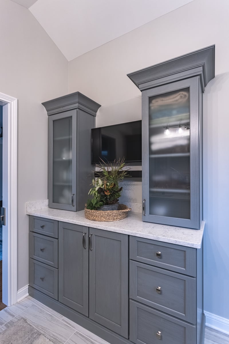 Bathroom storage with counter space and upper glass cabinet doors for display