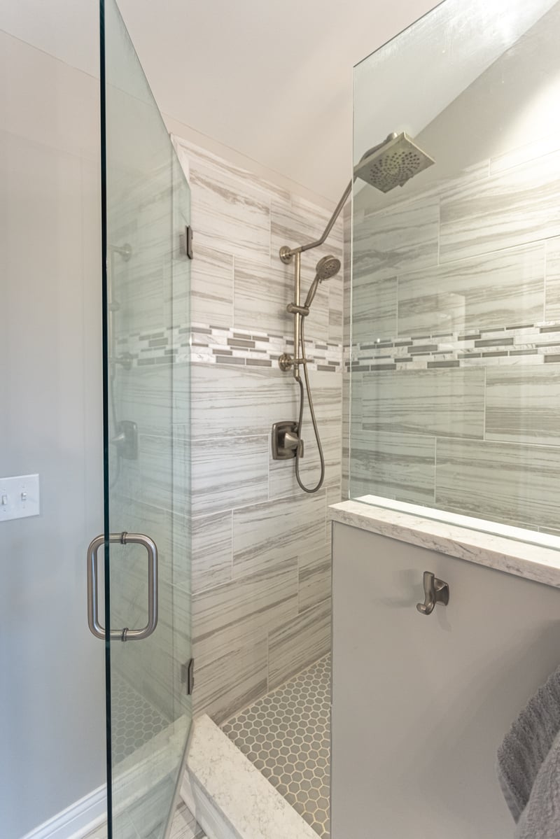 Walk-in shower in Cincinnati by Legacy builders group featuring gray large format tile and smaller accent tile
