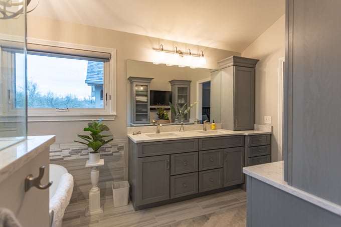 Wide view of gray cabinets and vanity in mater bathroom remodel in Cincinnati by Legacy Builders Group