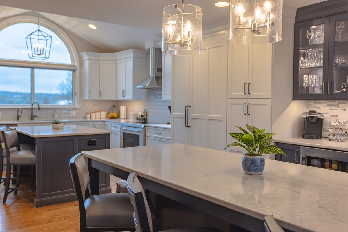 Open-concept kitchen renovation by Legacy Builders with dark cabinetry and double islands