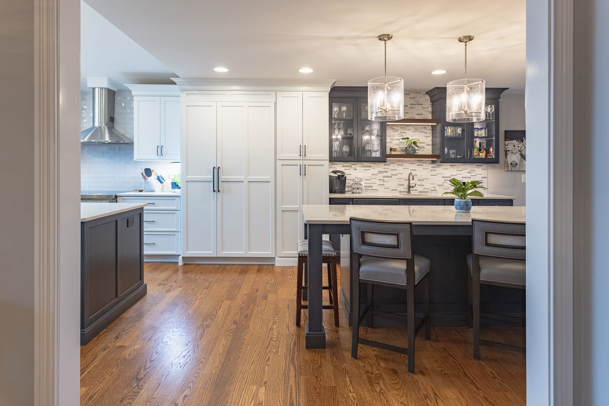 Two-tone kitchen remodel by Legacy Builders with blue island and hardwood floor