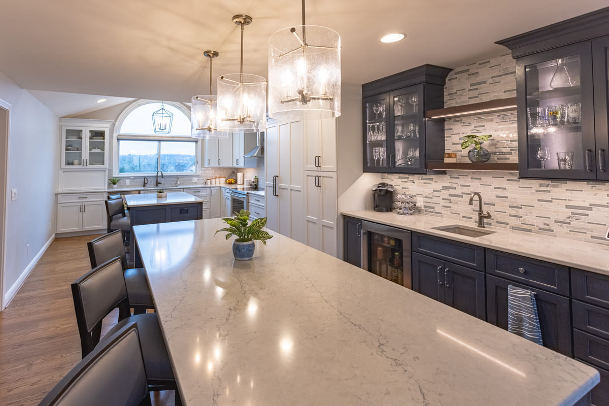 kitchen renovation by Legacy Builders with mosaic backsplash and three pendant light fixtures above island