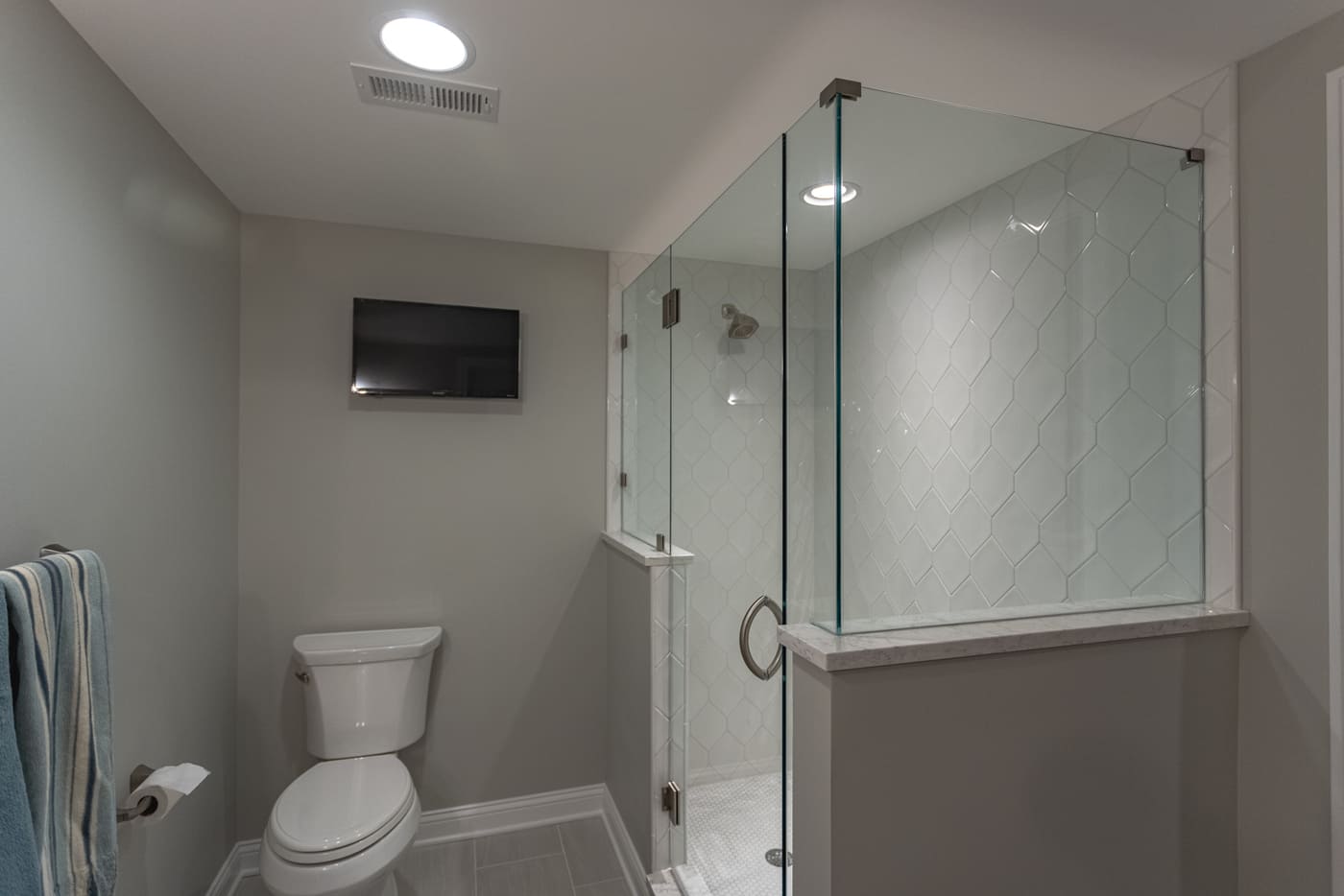 Walk-in shower with hexagonal tile in Ross County, OH basement bathroom remodel
