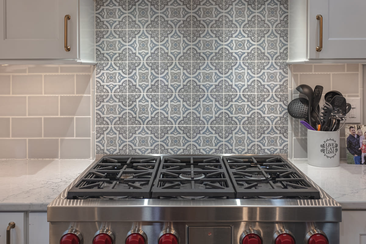 Mosaic tiling detail behind stove in Wetherington Country Club kitchen remodel by Legacy Builders Group