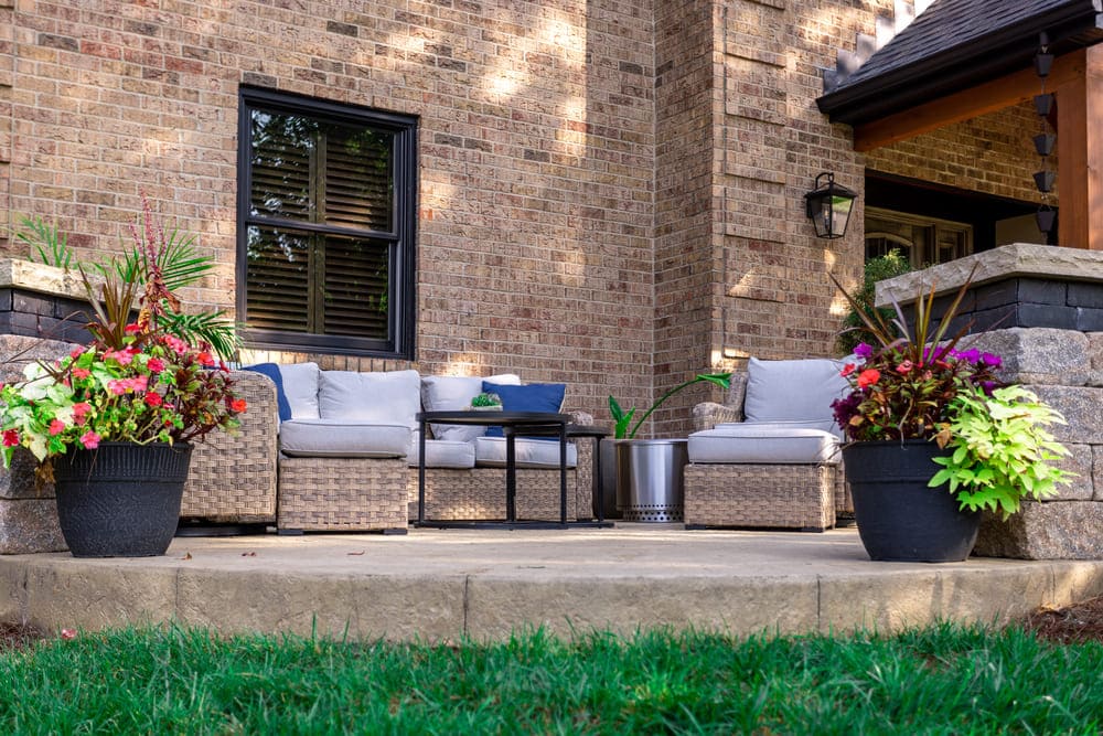 Concrete patio detail with potted plants and furniture