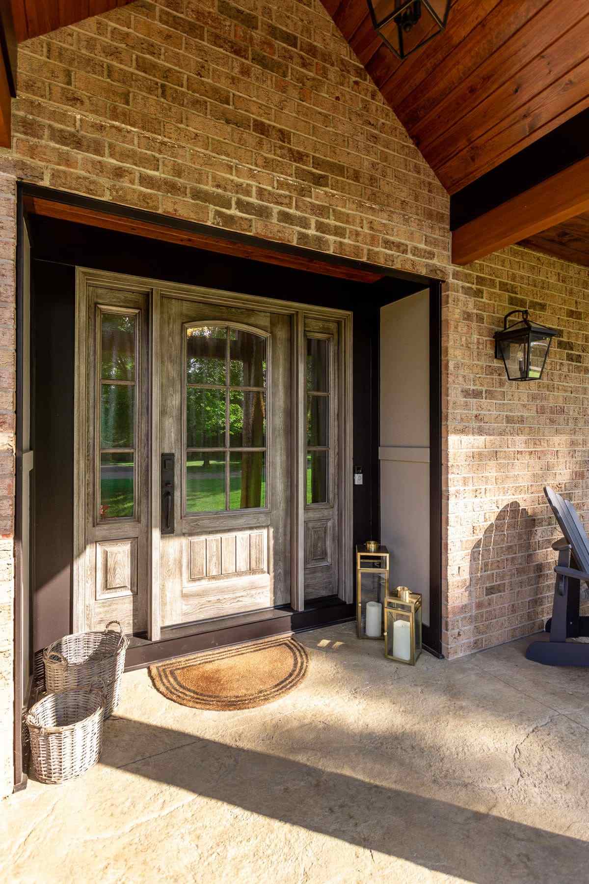 Front door of brick home with cedar roofing