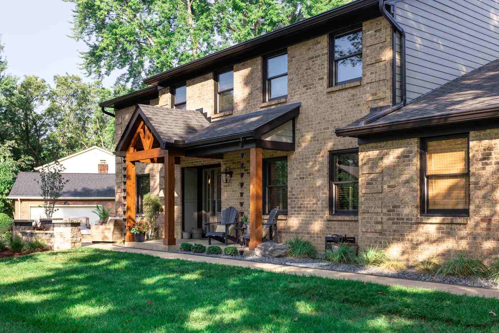 Front porch on brick home with a frame roof and oak posts