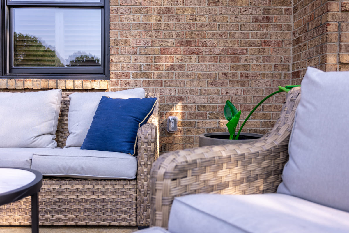 Shot of brick siding on home from front patio with furniture