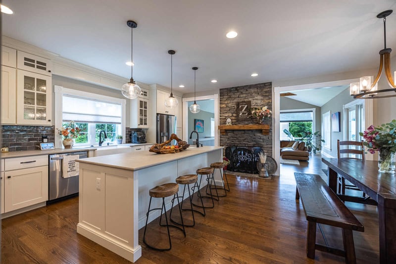 white kitchen cabinets and stone accent wall with fireplace in kitchen