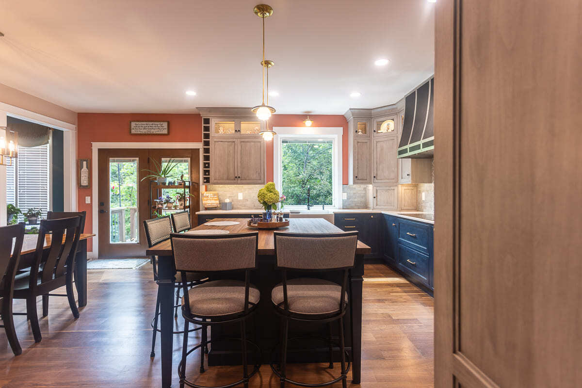 Legacy Builders Group kitchen remodel with two-tone Amish cabinets, island seating, and natural light.