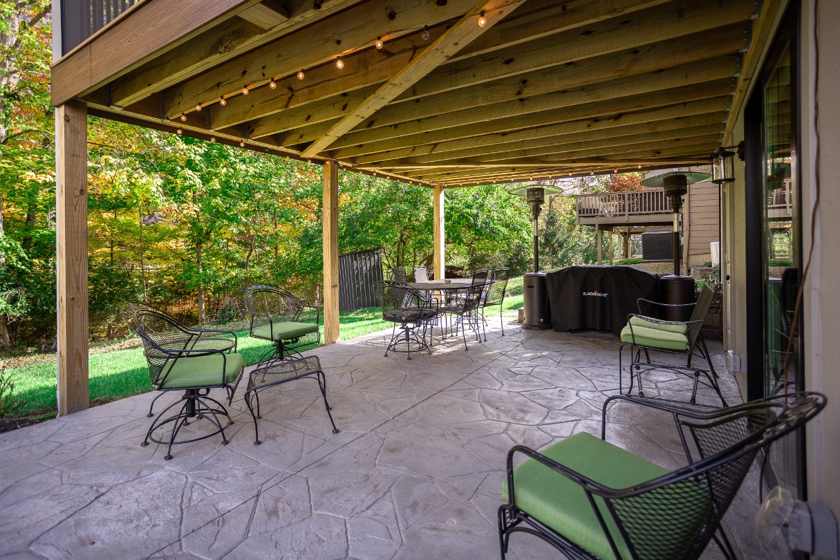 Outdoor living space beneath screened-in porch in Evendale, Ohio by Legacy Builders