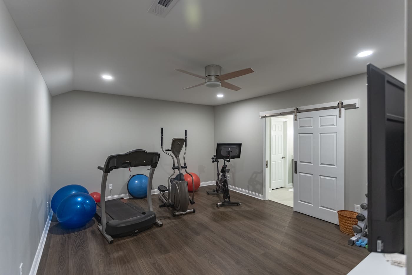 Home gym in finished Ross County basement renovation with recessed lighting