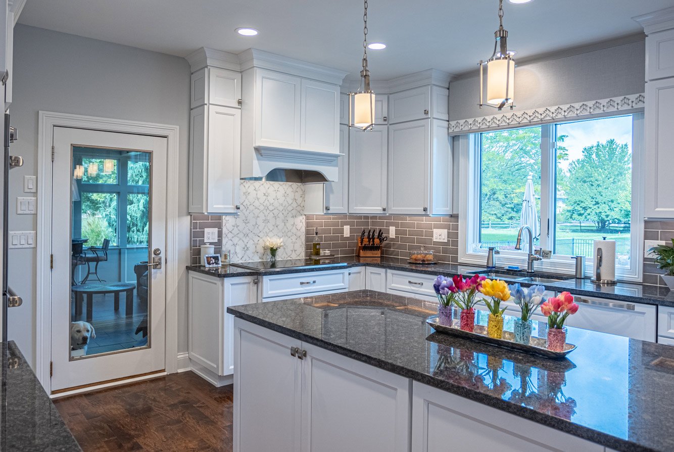 Kitchen island with white shaker storage cabinets and pendant lighting above Kitchen island with white shaker storage cabinets and pendant lighting above