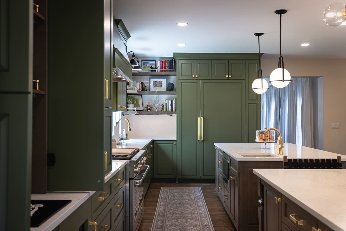 Kitchen remodel featuring floor-to-ceiling green cabinetry, wood island, quartz counters, brass fixtures, and open shelving.