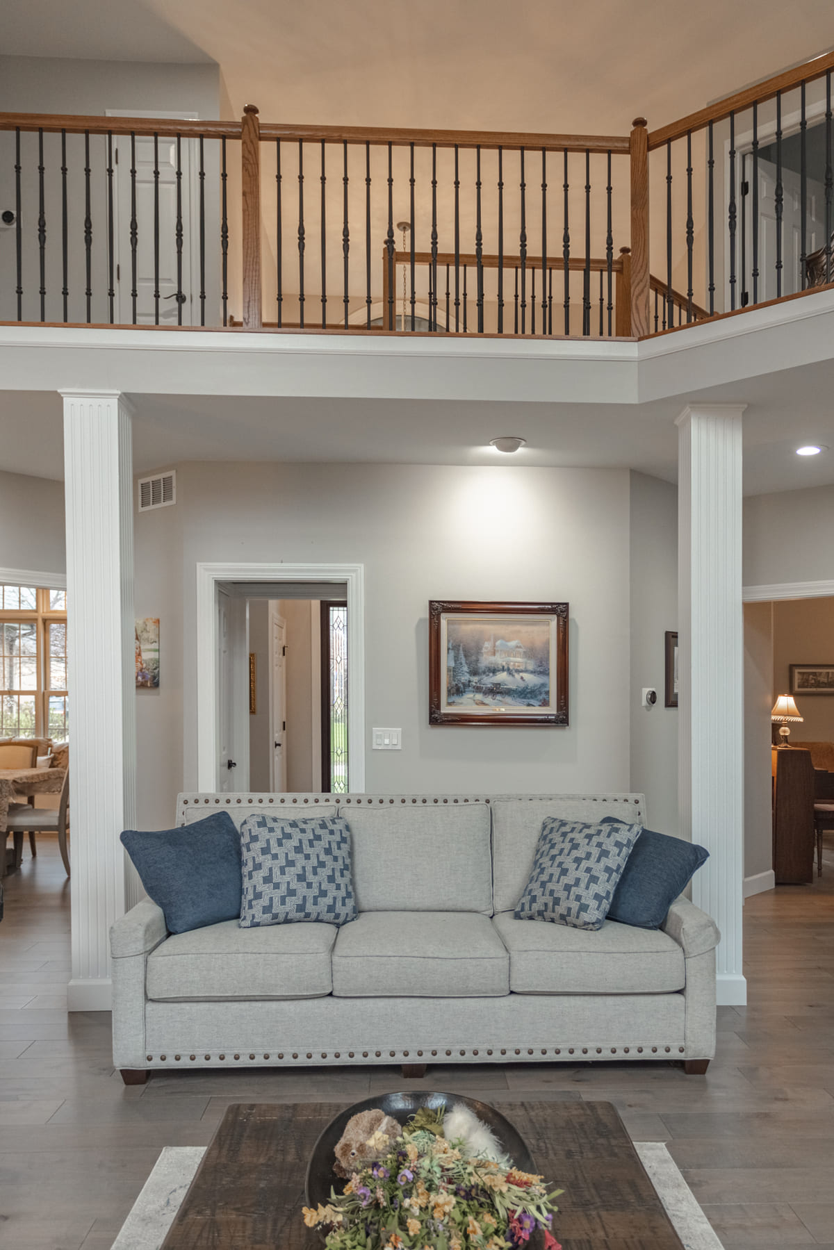 View of couch and second-story staircase railing in Cincinnati, OH living space remodel